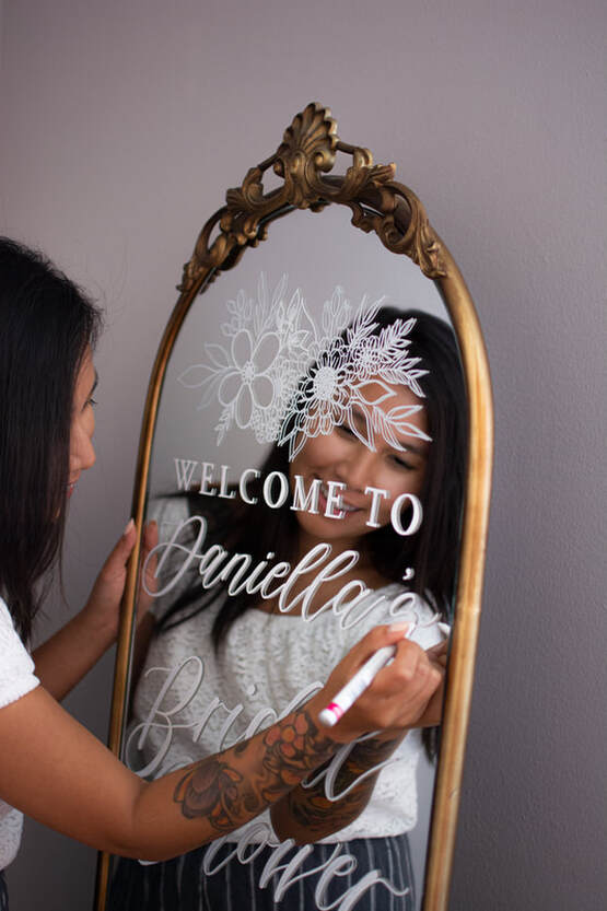 Calligrapher working on a Welcome Signage on Gold Framed Mirror in Toronto